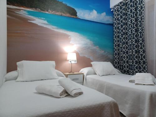 蒙福特·德·莱蒙斯La Casita de Plata的一张位于一间海滩画室的两张床