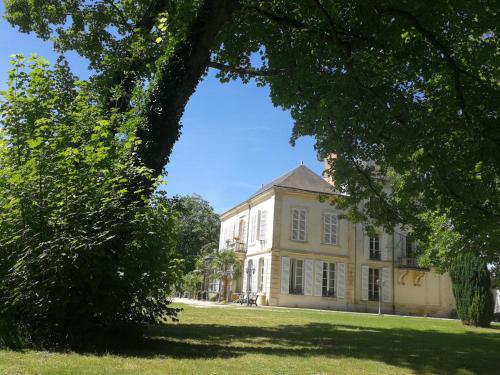 Val de VesleChâteau de Courmelois Champagne Guest House的一座有树木的白色大建筑