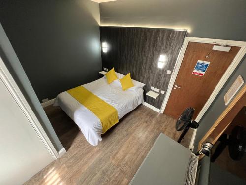 达灵顿dalesman hotel的一间小卧室,配有一张带黄色枕头的床