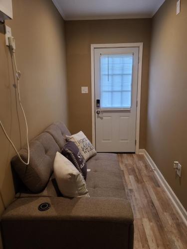 巴吞鲁日JAMMS tiny home的沙发,位于带门的房间的角落