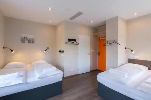 布拉格Minimino hotel的白色墙壁客房的两张床