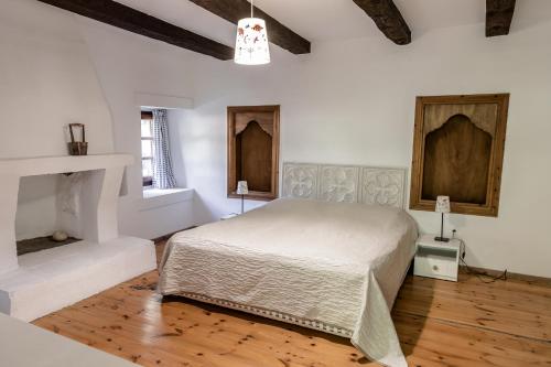 Metókhion ZográfouPorto Elea Camping & Bungalows的一间白色卧室,配有一张床和一个壁炉