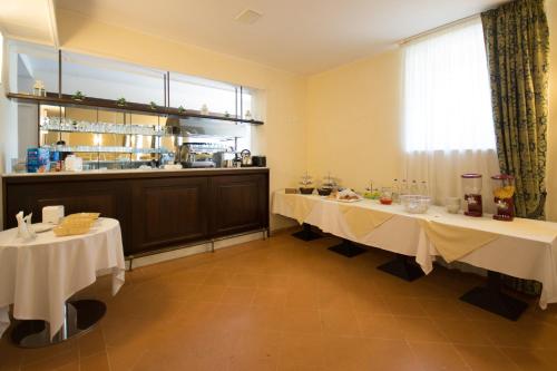安科纳Domus Stella Maris - Casa per Ferie的一间用餐室,配有2张带白色桌布的桌子