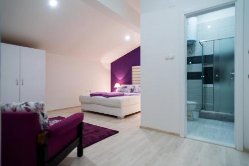 莫斯塔尔Purple rooms的一间卧室设有一张床和紫色的墙