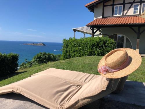 蒙达卡Adosado en la costa con excelentes vistas al estuario de Urdaibai的坐在沙发上戴草帽的人