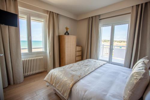 巴讷维尔-卡特里特Hôtel des Isles的一间卧室设有一张床,享有海景