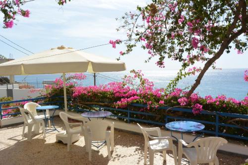 圣加利尼哈里克里亚旅馆的庭院配有桌椅和粉红色的鲜花