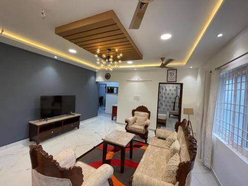 耶拉吉里Sharma Nivas Holiday Homestay的带沙发和平面电视的客厅