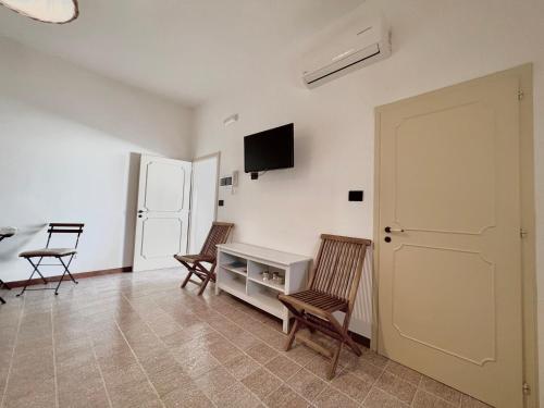 科尔萨诺Monolocale Cora的客厅配有两把椅子和一张白色桌子