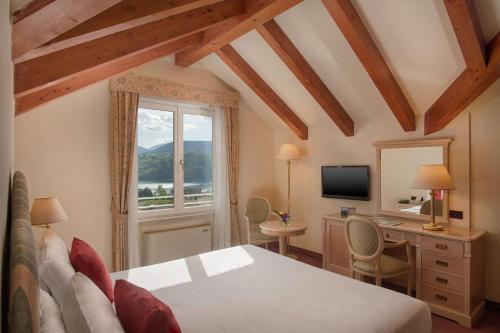 莱维科特尔梅贝拉维斯塔休闲酒店的一间卧室配有一张床、一张书桌和一个窗户。