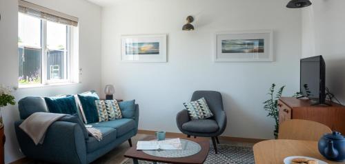 金斯布里奇Furlong Cottage @ Higher Stancombe Farm的客厅配有蓝色的沙发和椅子