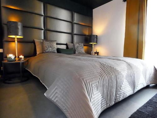 列日SuiteDreams - Relax Suite Liège的一间卧室配有一张带两盏灯的大型白色床。