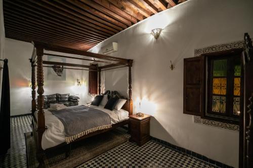 非斯Dar Chez Khadija的一间卧室设有天蓬床和窗户。