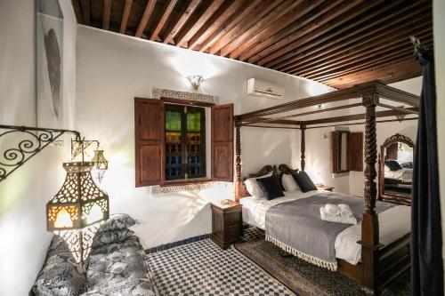 非斯Dar Chez Khadija的一间卧室设有天蓬床和窗户。