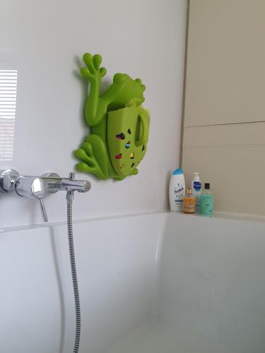克诺克－海斯特Stijlvolle vakantiewoning Den Baigneur aan zee的坐在浴室柜台上的绿色青蛙玩具