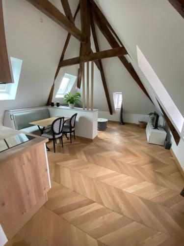 多尔德布列塔尼Studio centre ville的阁楼间铺有木地板,配有桌椅。