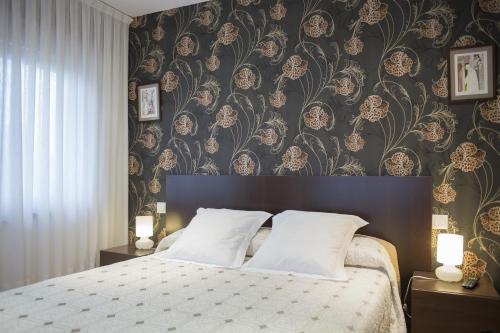 苏安塞斯昆塔纳23号酒店的一间卧室配有一张带花卉壁纸的大床