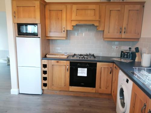 斯莱戈Atlantic way Apartment的厨房配有木制橱柜和黑炉灶烤箱。