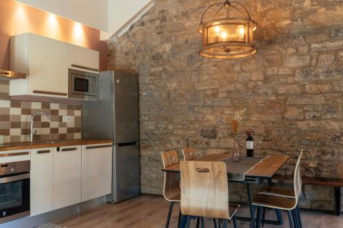 布罗托La Borda de Chelis的厨房配有餐桌和石墙