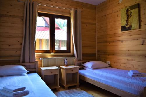 扎布利亚克Srna Chalet - Rooms的带窗户的客房内设有两张单人床。