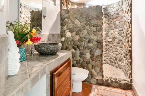 曼努埃尔安东尼奥Villas Oasis的一间带卫生间和石墙的浴室