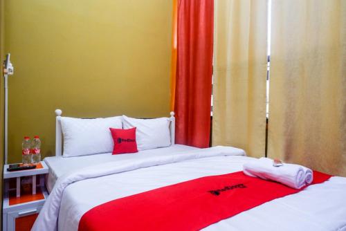 SawahanRedDoorz Syariah near Exit Toll Ngemplak Solo的红色和白色的客房内的两张床
