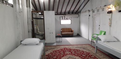 日惹Benara Shariah Homestay的一间设有两张床和椅子的房间