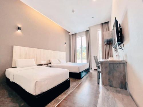 关丹KARANG TIMUR MOTEL的酒店客房设有两张床和电视。