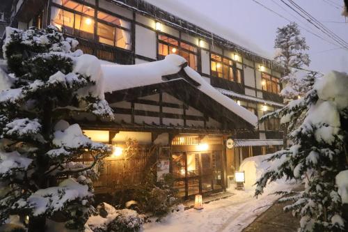 野沢野沢温泉　奈良屋旅館的一座被雪覆盖的建筑