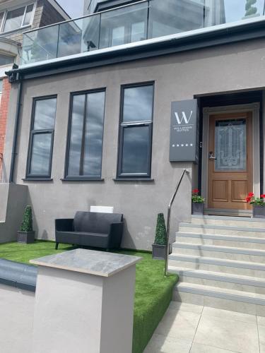 布莱克浦Willshaw Suites for families over 25 only的前面有一张黑色沙发的房子