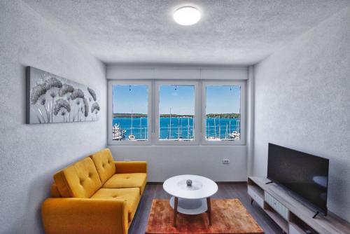 普拉Apartment Marina with sea view的客厅配有黄色椅子和电视