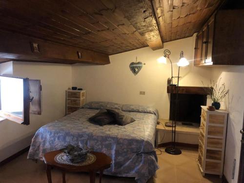 CollimentoLa Casa della Volpe的一间卧室配有一张床、一张桌子和一台电视。