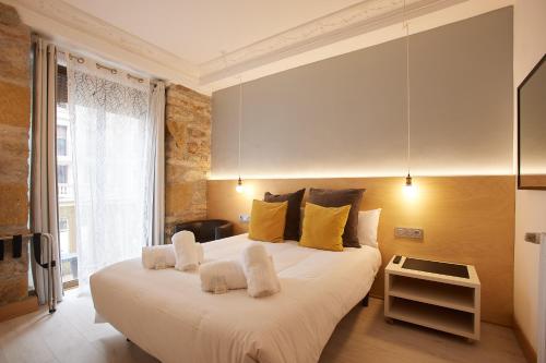 圣塞瓦斯蒂安Pensión Aia的卧室配有一张带黄色枕头的大型白色床。