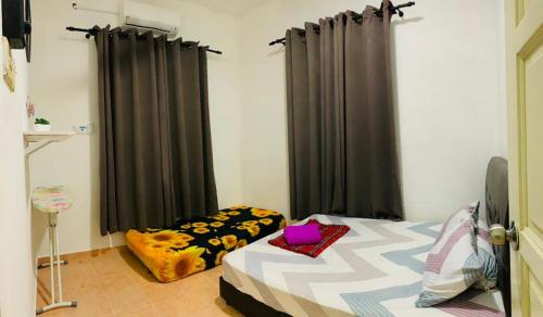 哥打巴鲁Nurul Amin Guest House Pantai Cahaya Bulan Kota Bharu的一间卧室配有一张带黑色窗帘的床