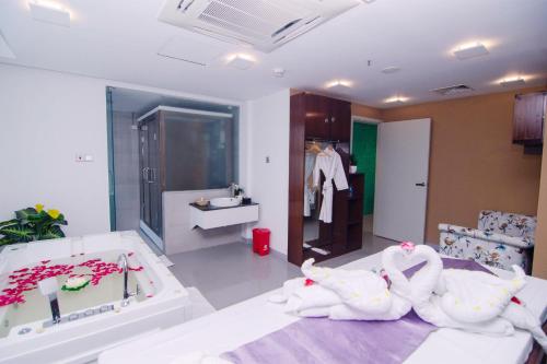 吉大港Pearl Harbour Business Hotel的浴室配有盥洗盆、浴缸和毛巾