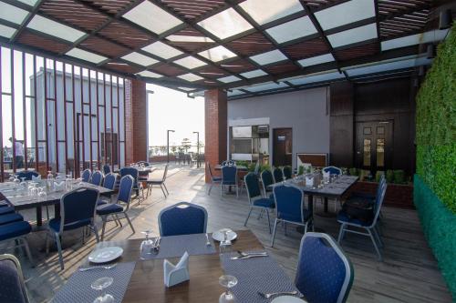 吉大港Pearl Harbour Business Hotel的餐厅的 ⁇ 染,配有桌椅