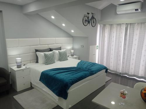 奥尔塔Casa Rua Velha的白色卧室配有一张带蓝色毯子的大床