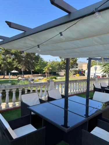 萨拉戈萨埃尔瑟斯尼酒店的露台配有桌椅和遮阳伞