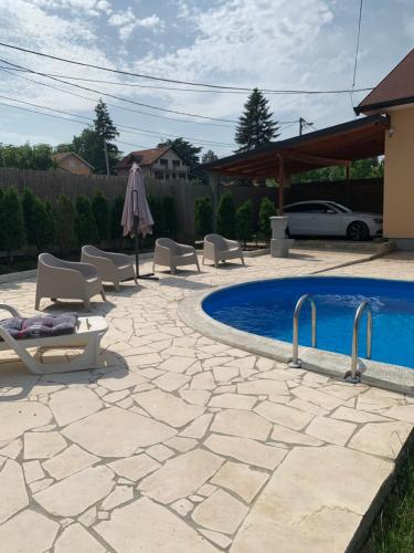 贝尔格莱德Mika’s Poolhouse的一个带椅子的庭院和一个游泳池