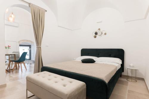 奥斯图尼Alba Luxury Suite的一间卧室配有一张床、一把椅子和一张桌子