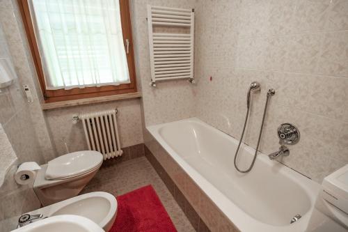 圣维吉利奥Apartment ARGENTIS Krumas-Living - Kronplatz的浴室配有卫生间、浴缸和水槽。