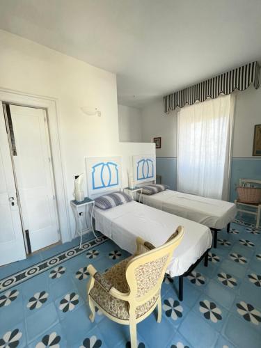 诺沃利Le Stanze del Monsignore的一间卧室配有两张床和椅子