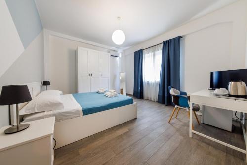 墨西拿Blue Apartment Messina的一间卧室配有一张床、一张桌子和一台电脑