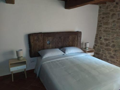 特拉西梅诺湖畔托罗Agriturismo L'Accolta的一间卧室配有一张大床和木制床头板