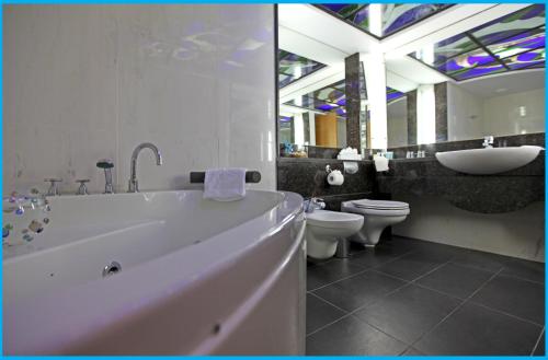 利马索尔波塞多尼亚海滩酒店的带浴缸、盥洗盆和卫生间的浴室