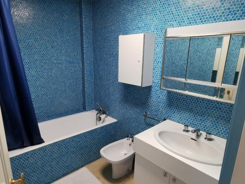 莱萨布勒-多洛讷Le Foch - Appartement face mer avec garage的蓝色瓷砖浴室设有水槽和卫生间