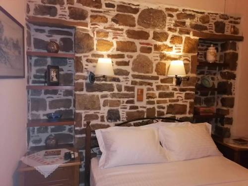 米里纳traditional house in Androni的一间卧室设有石墙、一张床和灯