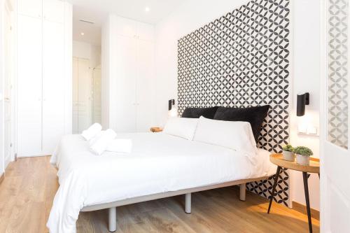 巴塞罗那Cozy Apartment close to Passeig de Gracia的卧室配有白色的床和黑白墙
