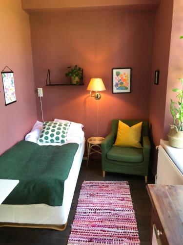 孙讷FärgLabbets Bed and Breakfast的一间卧室配有一张床和一把绿色椅子