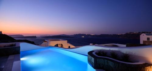 阿克罗蒂里Acro Blue Luxury Villas的黄昏时分带蓝色灯光的游泳池